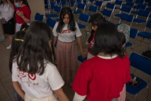 A group of young girls in red shirts are standing in a circle